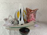 a white vase sitting on top of a table next to a bowl