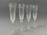 four clear wine glasses sitting next to each other on a table