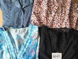 trois hauts et un haut-soutien-gorge posés sur une boîte en carton