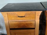 pair of wooden nightstands with black granite top