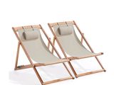 pair of wooden and canvas lounge chairs on a white background