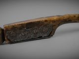 a close up of a knife on a table with a gray background