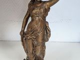 bronze statue of a woman holding a bird on a base