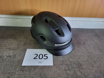 un casque posé par terre à côté d'un panneau indiquant « 205 »