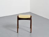an image of a chair with a yellow seat in a white room