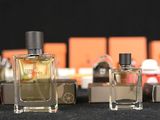 bottles of perfume are lined up on a table in front of boxes