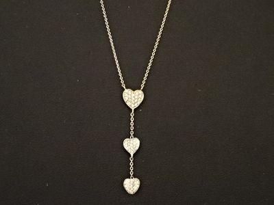 une femme portant un collier auquel sont suspendus trois cœurs