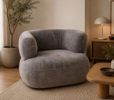 un fauteuil gris dans un salon avec une table basse