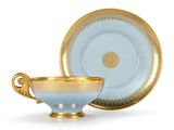 tasse et soucoupe dorées et bleues sur fond blanc