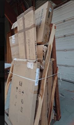 une pile de cartons posée sur une palette devant la porte d'un garage