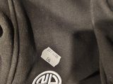 the back of a black jacket with a white logo on it