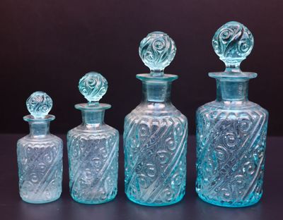 trois bouteilles en verre bleues posées les unes à côté des autres sur une table