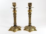 a pair of brass candlesticks on a white background