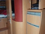 a view of a small room with a bed and a refrigerator