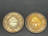 deux pièces, une en or et une en argent, posées sur une surface noire