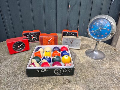a box of billiard balls and a clock on a table