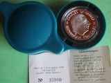 a blue bowl with a coin in it next to a receipt