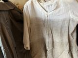three shirts hanging on a clothes rack in a room