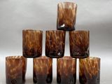 six glasses sitting on top of each other on a table