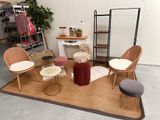 Plusieurs chaises et tabourets sont disposés sur un tapis dans une pièce