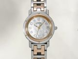 a silver and gold wrist watch with a white dial