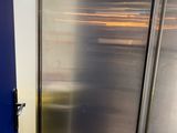a stainless steel refrigerator in a kitchen with a blue door