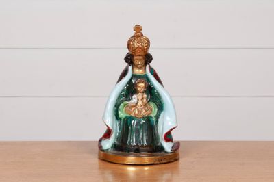 une figurine représentant une femme tenant un enfant dans ses bras, posée sur une table