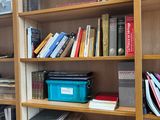 a book shelf with many books on it in a room