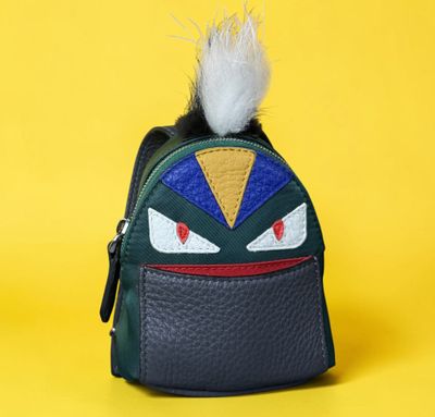 a close up of a small bag with a furry ball on it