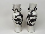 une paire de vases noirs et blancs ornés de motifs de dragons