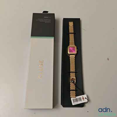 une photo d'une montre en or avec un cadran rose, dans un coffret