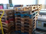 plusieurs palettes de bois sont empilées sur des palettes dans un entrepôt