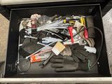 a metal box filled with assorted tools on the ground