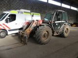 a white van parked next to a tractor in a warehouse