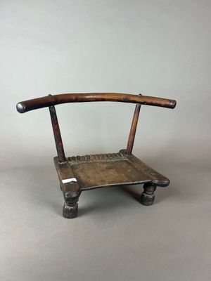 une vieille chaise en bois posée sur un sol gris