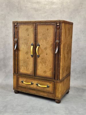 une vieille armoire en bois à deux portes, surmontée de poignées
