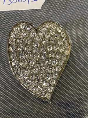 un gros plan d'une broche en forme de cœur posée sur une table