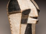 un gros plan d'un masque en bois orné d'un motif en noir et blanc