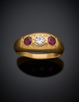 un gros plan d'une bague en or sertie d'un diamant et de rubis