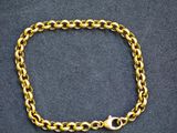 a gold chain bracelet on a black background