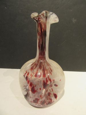 a glass vase with blood on it sitting on a table