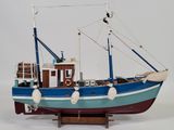 a model of a boat on a stand on a white surface