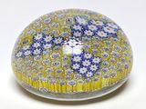 une boule en verre jaune et bleue décorée de fleurs