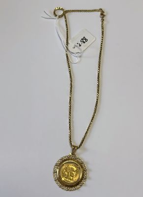 un collier en or composé d'une pièce suspendue à une chaîne et muni d'une étiquette