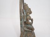bronze statue of a woman sitting on a bench with a harp