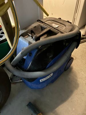 un aspirateur posé sur le sol à côté d'une chaise