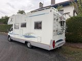 un camping-car blanc garé sur le bord de la route