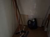 une photo d'une pièce avec un balai, des balais et un sac
