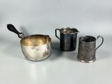 three silver cups and a silver jug on a white surface