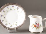 a small pitcher and a small plate on a stand